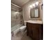 Bathroom with decorative vanity, framed mirror, and tiled shower-tub with glass doors at 6085 Simms St, Arvada, CO 80004