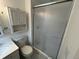 Functional bathroom with white vanity, toilet, medicine cabinet, and glass-enclosed shower at 6085 Simms St, Arvada, CO 80004