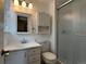 Well-lit bathroom with white vanity, mirror, medicine cabinet, toilet and glass-enclosed shower at 6085 Simms St, Arvada, CO 80004