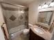 Tiled bathroom featuring tub with shower, vanity sink, and decorative mirror at 6085 Simms St, Arvada, CO 80004