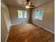 Bright bedroom with hardwood floors, neutral walls, two windows and a closet with sliding door at 6085 Simms St, Arvada, CO 80004