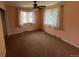 Neutral bedroom with standard ceiling fan, natural light from two windows, and standard brown carpet at 6085 Simms St, Arvada, CO 80004