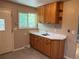 Bright kitchen corner with oak cabinets, white counters, and a stainless steel sink offering a practical cooking space at 6085 Simms St, Arvada, CO 80004