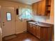 Functional laundry area featuring wooden cabinets, laminate countertop, and exterior door at 6085 Simms St, Arvada, CO 80004