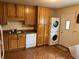 Convenient laundry area includes a washer, dryer, oak cabinets, and laminate countertops at 6085 Simms St, Arvada, CO 80004