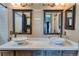 Modern bathroom featuring a double vanity with vessel sinks, dark wood cabinets and black framed mirrors at 8459 Sweet Clover Way, Parker, CO 80134