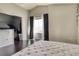 Bedroom with dark laminate flooring, large window with black-out curtains, and closet at 8459 Sweet Clover Way, Parker, CO 80134