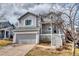 Charming gray two-story home featuring a front porch, attached garage and beautiful landscaping at 8459 Sweet Clover Way, Parker, CO 80134