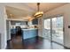 Bright kitchen featuring blue cabinets, light countertops, stainless appliances, and sliding doors to the deck at 8459 Sweet Clover Way, Parker, CO 80134