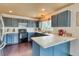 Stylish kitchen featuring blue cabinets, light countertops, stainless appliances, and lots of natural light at 8459 Sweet Clover Way, Parker, CO 80134