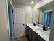 Bathroom featuring double sinks with black faucets, gray cabinetry and a large mirror at 18328 E 93Rd Pl, Commerce City, CO 80022