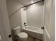 Bright bathroom featuring a white subway tiled shower-tub, black fixtures, and wood look floors at 18328 E 93Rd Pl, Commerce City, CO 80022