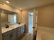 Bright bathroom featuring double sinks with modern faucets and a large mirror at 18328 E 93Rd Pl, Commerce City, CO 80022