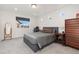 This bedroom features a gray bed, carpet, and dark wood dresser, desk and floors at 5480 Danube St, Denver, CO 80249