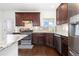 The kitchen features dark cabinets, tile backsplash, stainless steel appliances, and granite countertops at 5480 Danube St, Denver, CO 80249
