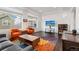 Stylish living room with gray sofa, orange chairs, colorful rug and dark wood floors at 5480 Danube St, Denver, CO 80249