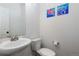 Bright powder room features white fixtures, fresh paint and modern marine life paintings at 5480 Danube St, Denver, CO 80249