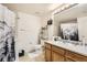 Clean bathroom with shower/tub combo, wood vanity, and updated fixtures at 5800 Tower Rd # 103, Denver, CO 80249