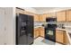 Well-equipped kitchen featuring black appliances and ample wood cabinetry at 5800 Tower Rd # 103, Denver, CO 80249