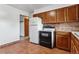 Kitchen featuring tile floors, wooden cabinets and white appliances at 4940 W 9Th Ave, Denver, CO 80204