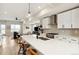 Contemporary kitchen featuring white cabinetry, stainless steel appliances, an island with seating, and modern lighting at 3580 Uinta St # 17, Denver, CO 80238