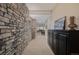 Hallway features a stone accent wall with decorative cabinet and a glimpse into the living area at 10698 Mountaingate Ct, Littleton, CO 80126