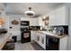 Modern kitchen with white cabinets, black appliances, and a breakfast bar at 8377 Mitze Dr, Denver, CO 80221