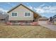 Traditional two-story home boasts an attached garage and brick accents at 7949 W Portland Ave, Littleton, CO 80128