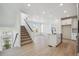 Open-concept living area with stairs and kitchen, featuring modern finishes at 1243 Rhett Dr, Erie, CO 80026