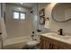 Bright bathroom features white subway tile, framed artwork, and a modern vanity with a round mirror at 10053 Lewis St, Broomfield, CO 80021