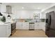 Modern kitchen with stainless steel appliances, sleek white cabinets, and a stylish backsplash at 10053 Lewis St, Broomfield, CO 80021