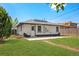 Landscaped backyard with new grass, a concrete patio, and a freshly painted white house with black trim at 3640 Forest St, Denver, CO 80207
