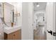 Modern bathroom sink and mirror with views down the hallway at 3640 Forest St, Denver, CO 80207