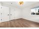 Empty bedroom with wood floor, neutral paint, one window, and two white closet doors at 3640 Forest St, Denver, CO 80207