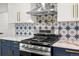 Modern kitchen featuring stainless steel appliances, stylish backsplash and custom white and blue cabinets at 3640 Forest St, Denver, CO 80207
