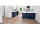 Open kitchen with wood floors, navy cabinets, white counter tops, and stainless steel appliances at 3640 Forest St, Denver, CO 80207