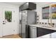Kitchen with stainless appliances, white backsplash, and dark blue cabinets with gold hardware at 3640 Forest St, Denver, CO 80207
