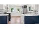 Bright kitchen features stainless appliances, wood floor, and navy blue cabinets with gold hardware at 3640 Forest St, Denver, CO 80207