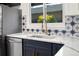 Close up of kitchen sink with white countertops and blue star-patterned backsplash at 3640 Forest St, Denver, CO 80207