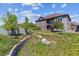 Picturesque backyard featuring a patio, balcony, lush lawn, and retaining wall at 6948 W Jewell Dr, Lakewood, CO 80227