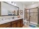 Bathroom featuring a vanity with sink and mirror, as well as a tiled shower stall with a glass door at 6948 W Jewell Dr, Lakewood, CO 80227