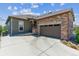 View of a single Gathering home showing the garage, front door, and manicured landscaping at 6948 W Jewell Dr, Lakewood, CO 80227