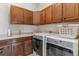 Functional laundry room with ample cabinet space, sink, and modern washer and dryer at 6948 W Jewell Dr, Lakewood, CO 80227