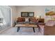 Living room featuring a couch with decorative pillows, a wooden coffee table, and neutral-toned carpet at 6948 W Jewell Dr, Lakewood, CO 80227