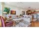 A spacious living room with hardwood floors, neutral paint, and a view into the kitchen at 6948 W Jewell Dr, Lakewood, CO 80227