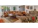 Inviting living room with a plush sectional sofa, area rug, patterned armchair, and plenty of natural light at 6948 W Jewell Dr, Lakewood, CO 80227