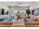 Bright living room featuring a stone fireplace, a ceiling fan, and access to a balcony with views at 6948 W Jewell Dr, Lakewood, CO 80227