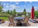 Charming patio area featuring a metal fire pit table, comfortable seating, and a red patio umbrella at 6948 W Jewell Dr, Lakewood, CO 80227
