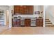 Charming wet bar featuring wooden cabinets, granite countertops, stainless steel appliances, and convenient wine cooler storage at 6948 W Jewell Dr, Lakewood, CO 80227