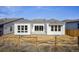 Rear exterior of a modern home featuring white siding, large windows, and a spacious backyard at 17054 Hop Clover Ave, Parker, CO 80134